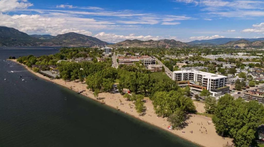 birds eye view of Gyro beach, one of the best beaches in Kelowna, with The Shore hotel in the background