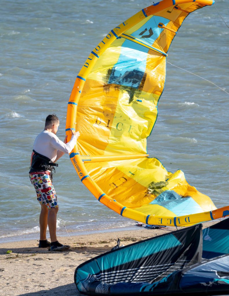 kite surfer on the beach setting up their gear before heading out on the water