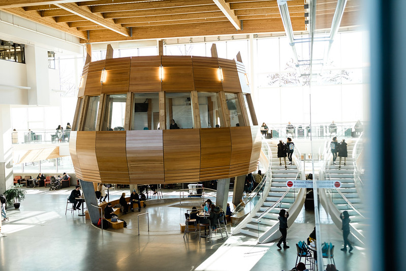 interior view of the okanagan college centre for learning, showing a modern design with a wooden circle centre room for studying and connecting with students