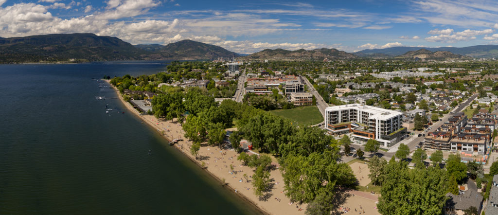 birds eye view of The Shore Kelowna, an apartment-hotel, with surrounding Pandosy neighbourhood and Gyro beach in the foreground